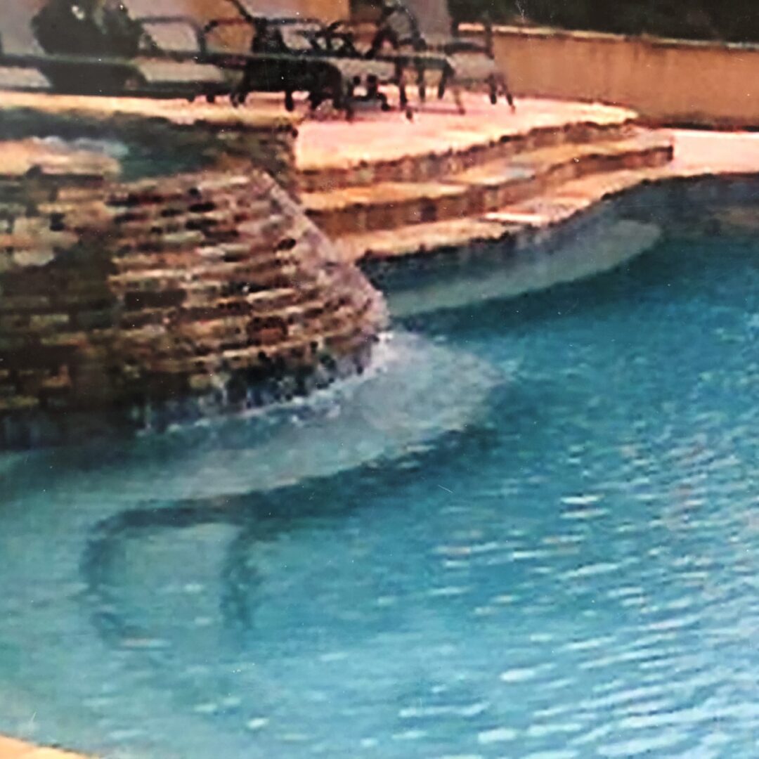 A swimming pool with brick stairs